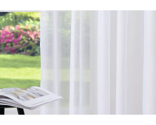 Světlá, průsvitná záclona před oknem s výhledem do zahrady