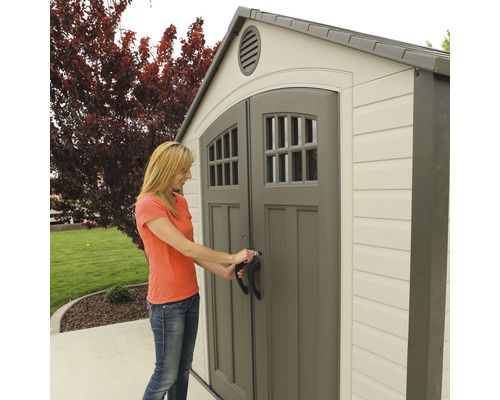Žena otevírá zahradní kůlnu s dvoukřídlými dveřmi a okny