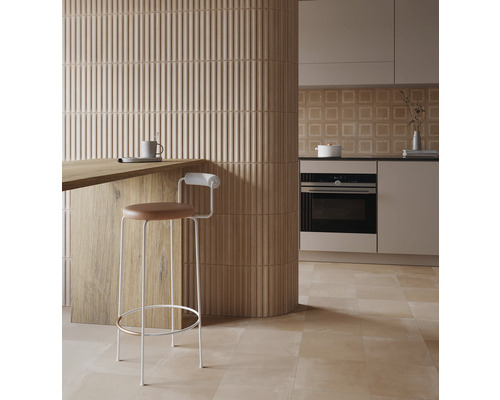 Světlá kuchyně s obkládačkami, pracovní deskou a barovou stoličkou