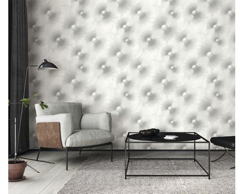Obývací pokoj s křeslem, stolem a tapetou se vzorem knoflíků