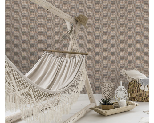 Pohled na pokoj s tapetou se vzorem rybí kosti, houpací sítí, košem a dekoracemi.