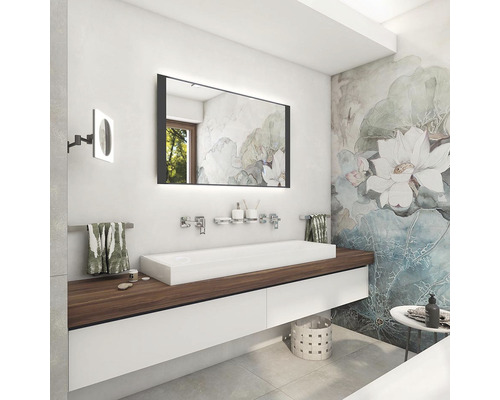 Moderní koupelna s osvětleným zrcadlem, umyvadlem a květinovou tapetou