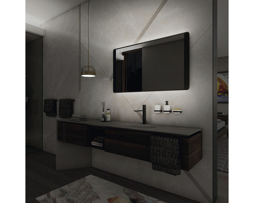 Moderní koupelna s umyvadlem, zrcadlem s osvětlením a odpovídajícími doplňky.