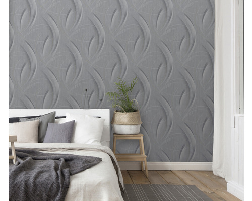 Ložnice s šedou trojrozměrnou tapetou a bílou postelí