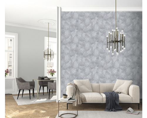 Světlý obývací pokoj s pohovkou, stolem, židlemi, lampou a vzorovanou tapetou