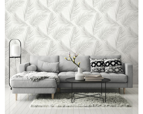 Obývací pokoj s šedou pohovkou a tapetou s listovým vzorem