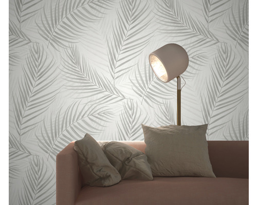 Obývací pokoj s pohovkou, stojací lampou a tapetou se vzorem listů