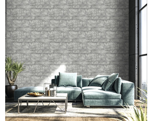Obývací pokoj s šedou tapetou s cihlovým vzorem, pohovkou a rostlinou
