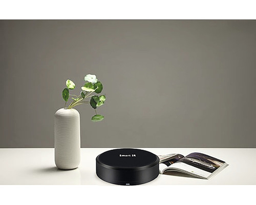 Chytré infračervené ovládání na stole s vázou a časopisem