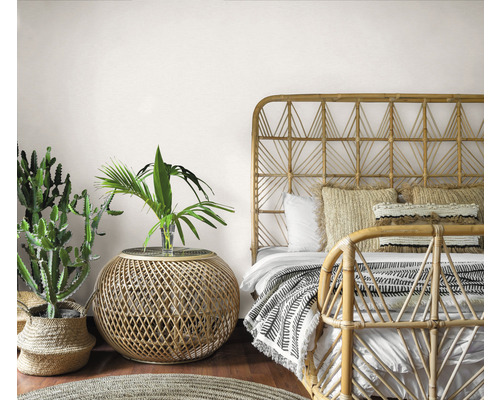 Ložnice v bohémském stylu s bambusovou postelí, příručním stolkem a pokojovými rostlinami