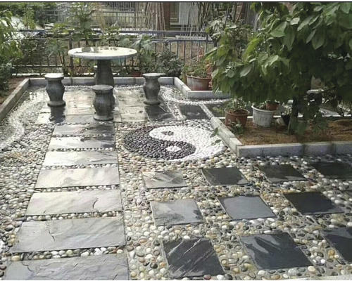 Zahradní scéna s kamenným stolem, židlemi, chodníkovými deskami a štěrkem