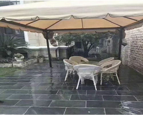 Zahradní scéna s altánem, zahradním stolem a židlemi na kamenné podlaze