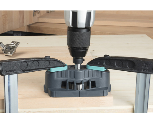 Kolíkovací vrtací přípravek s vrtačkou a šroubovacími svorkami na dřevěné desce