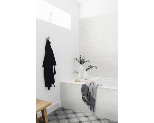 Světlá koupelna s vanou, ručníkem, rostlinami, županem a vzorovanou dlažbou