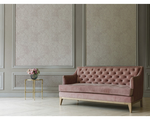 Obývací pokoj s nástěnnými panely, vzorovanou tapetou, prošívanou pohovkou a příručním stolkem s květinami