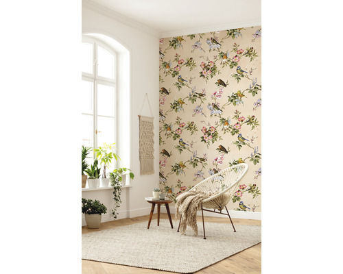 Světlý pokoj s květinovou tapetou, kulatým křeslem a pokojovými rostlinami