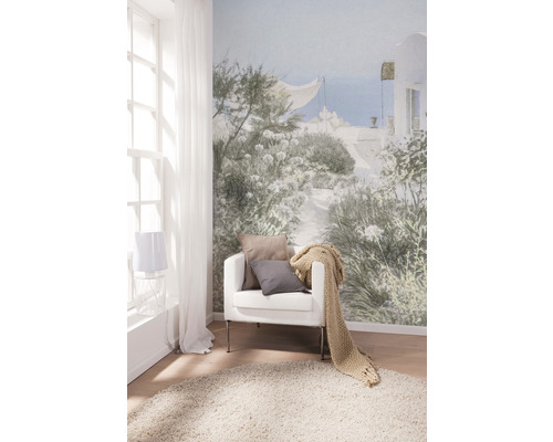 Obývací pokoj s fototapetou, křeslem, polštáři, přehozem a kobercem pro světlou a přátelskou atmosféru.