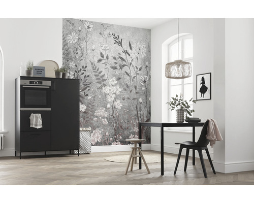 Světlá místnost s kuchyňským stolem, židlí, skříňkou s troubou a nástěnnou tapetou s květinovým vzorem.