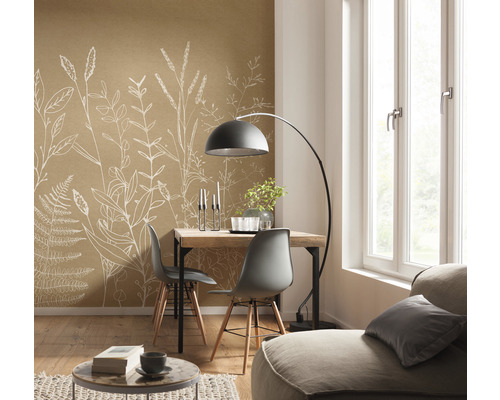 Světlá místnost s jídelním stolem, židlemi, stojací lampou a hnědou tapetou s rostlinnými motivy