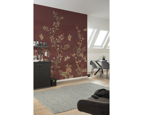 Obývací pokoj s květinovou tapetou v červenohnědé barvě, jídelním stolem, židlemi a šedým kobercem.