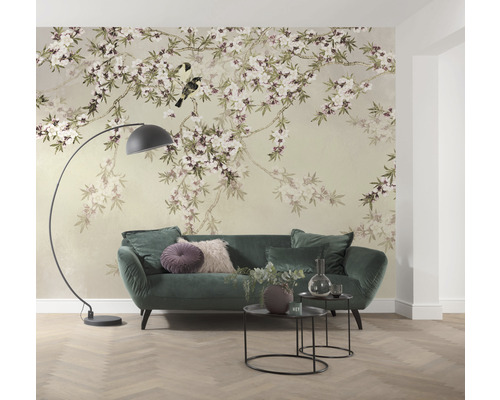 Obývací pokoj s květinovou tapetou, pohovkou, stojací lampou a odkládacími stolky