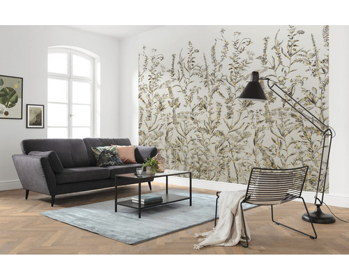 Obývací pokoj s pohovkou, kobercem, stojací lampou, židlí a vzorovanou tapetou s rostlinnými motivy