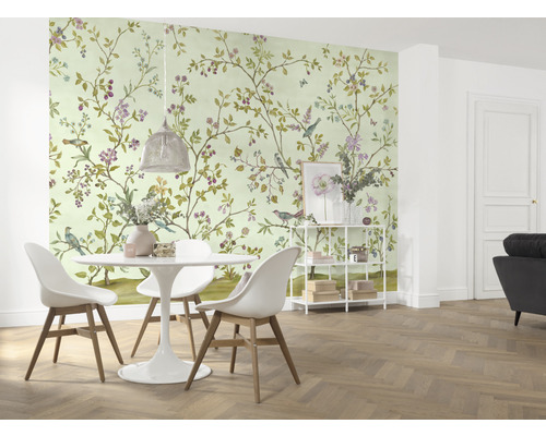 Jídelna s tapetou se vzorem ptáků a květin, jídelním stolem a židlemi.