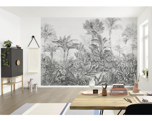 Obývací pokoj s fototapetou s motivem džungle, zobrazující palmy a leopardy.