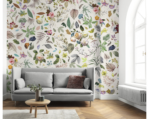 Obývací pokoj s pohovkou a květinovou tapetou s listy a květy.