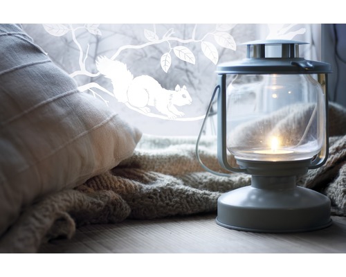 Dekorativní scéna s polštářem, pletenou dekou a lucernou se svíčkou