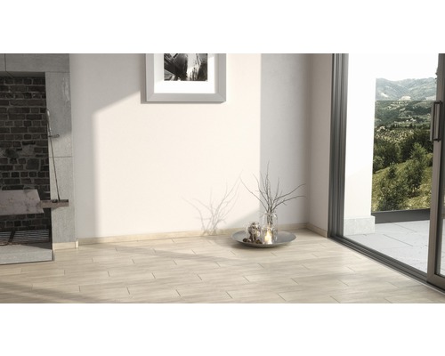 Světlá místnost s dřevěnou podlahou, krbem a výhledem do zeleně