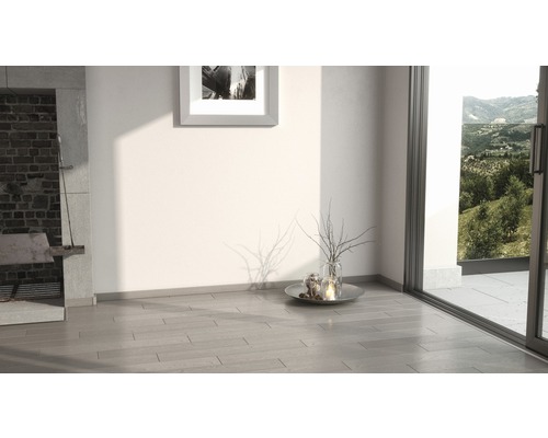 Světlá místnost s dřevěnou podlahou, krbem a výhledem do zeleně