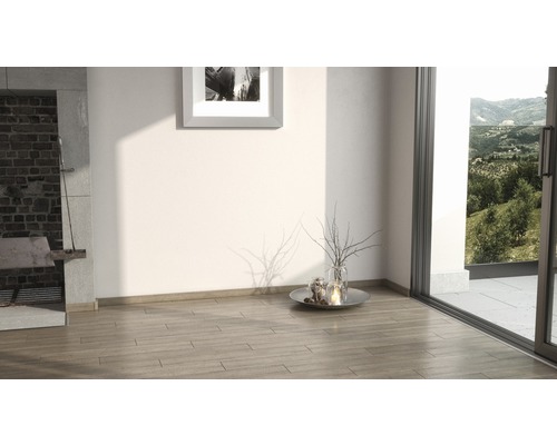 Světlá místnost s krbem, dřevěnou podlahou a výhledem do zeleně