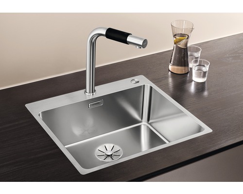 Nerezový dřez s vodovodní baterií na pracovní desce