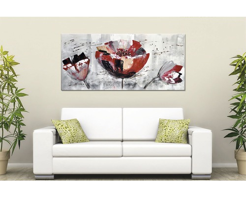 Obraz s květinovým motivem nad bílou pohovkou