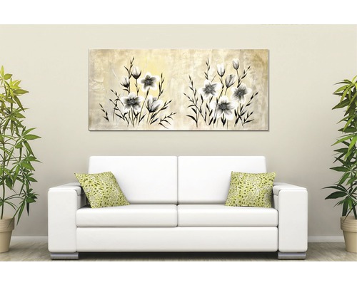 Dekorativní nástěnný obraz s květinovým motivem nad pohovkou v obývacím pokoji.