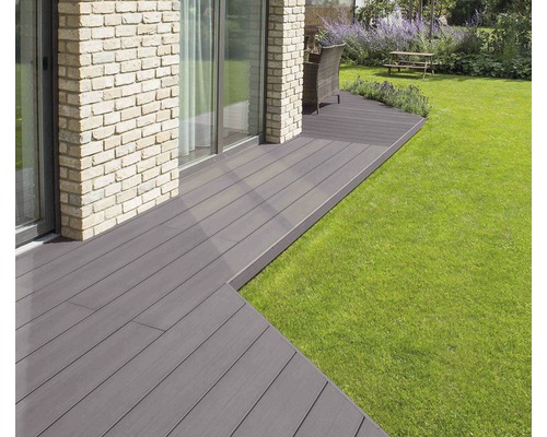 Terasa z dřevěných prken vedle trávníku v zahradě