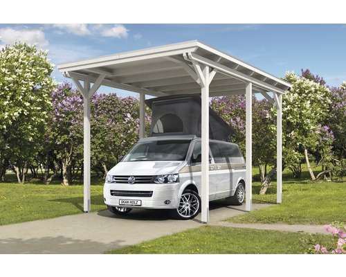 Volně stojící dřevěný přístřešek pro auto s autem na dlážděném povrchu před stromy