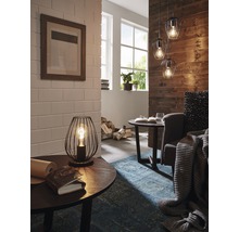 Interiérový pohled s stolní lampou, závěsnými svítidly a dekorativními prvky pro útulnou atmosféru bydlení