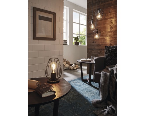 Interiérový pohled s stolní lampou, závěsnými svítidly a dekorativními prvky pro útulnou atmosféru bydlení