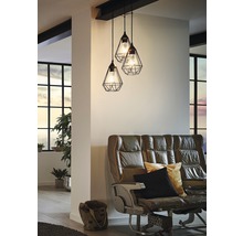 Závěsná lampa se třemi svítidly nad pohovkou v obývacím pokoji.