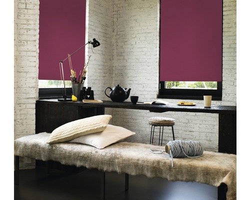 Obývací pokoj se dvěma okny a bordó roletami, psací stůl a lavice