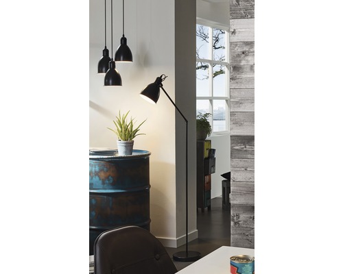 Interiér se závěsnými svítidly, stojací lampou a dekoracemi na ropném sudu