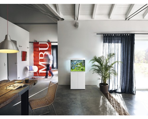 Obývací pokoj s akváriem na skříňce, stolem a židlemi.