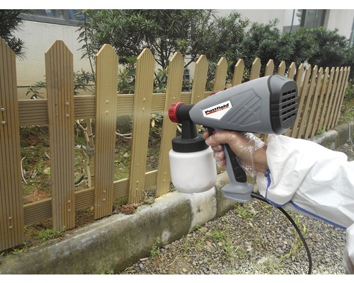 Stříkací systém na barvy používaný při natírání dřevěného plotu