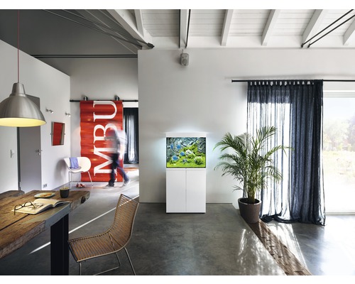 Obývací pokoj s akváriem na skříňce, jídelním stolem a závěsy