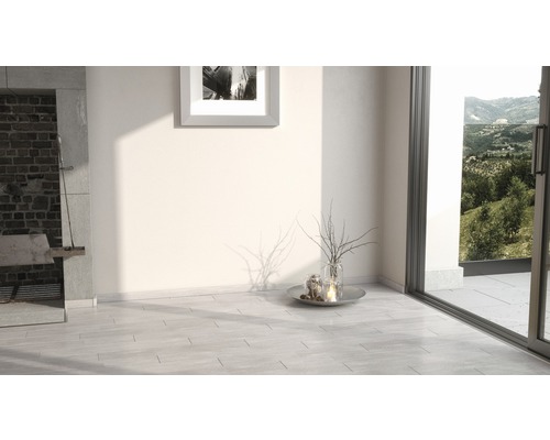 Světlá místnost s grilem, obrazem na zdi, dekorací a posuvnými dveřmi do zahrady