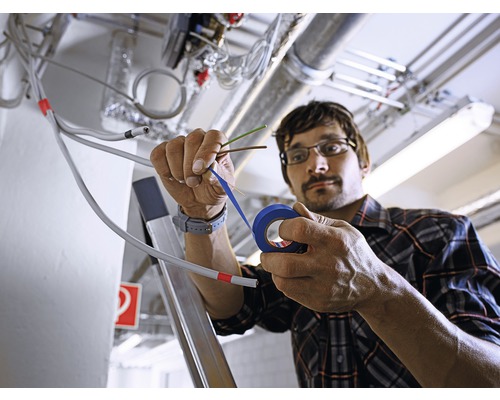 Elektrikář izoluje kabely izolační páskou