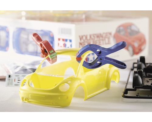 Žlutý model auta Volkswagen New Beetle ve výstavbě s nářadím