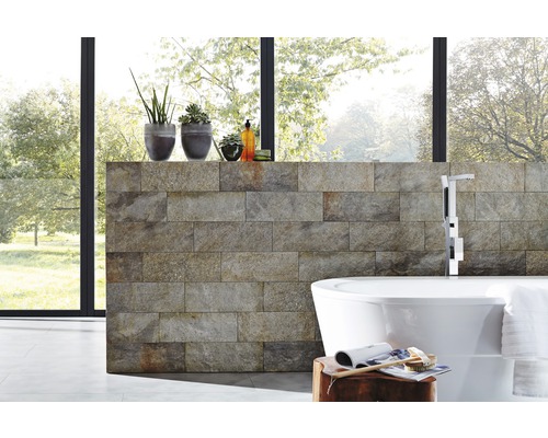 Moderní koupelna s obkladem z přírodního kamene, volně stojící vanou a pokojovými rostlinami